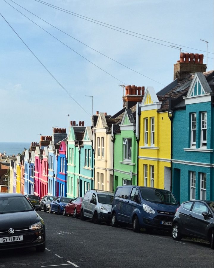 A row of brightly painted terraced houses on a hill in Brighton