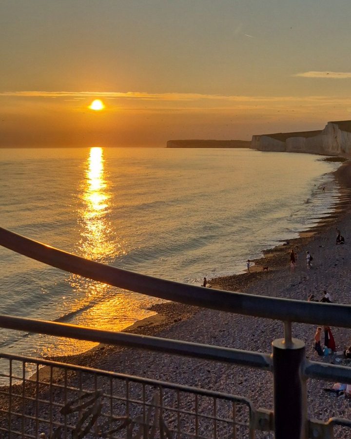 Sunset over the sea beside white chalk cliffs on the Sussex coast