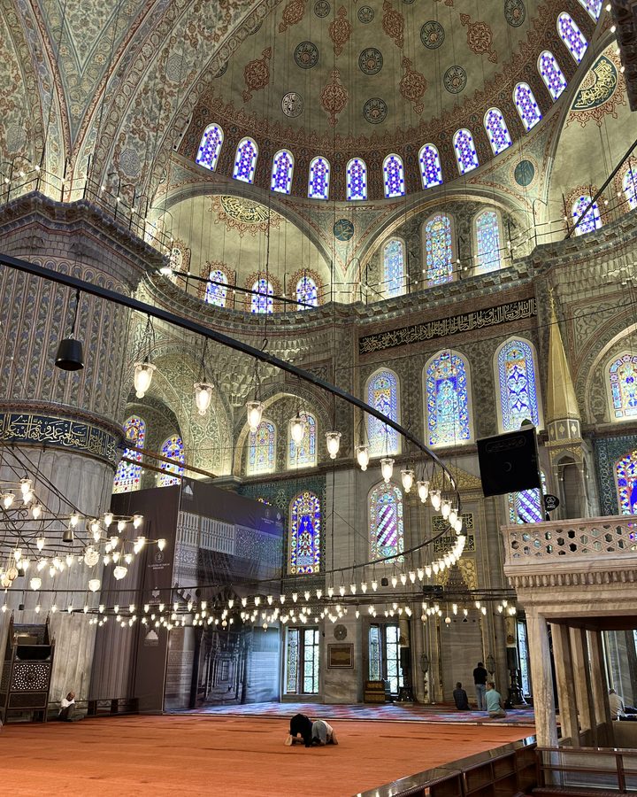 The tiled domes and stained-glass windows inside the Blue Mosque