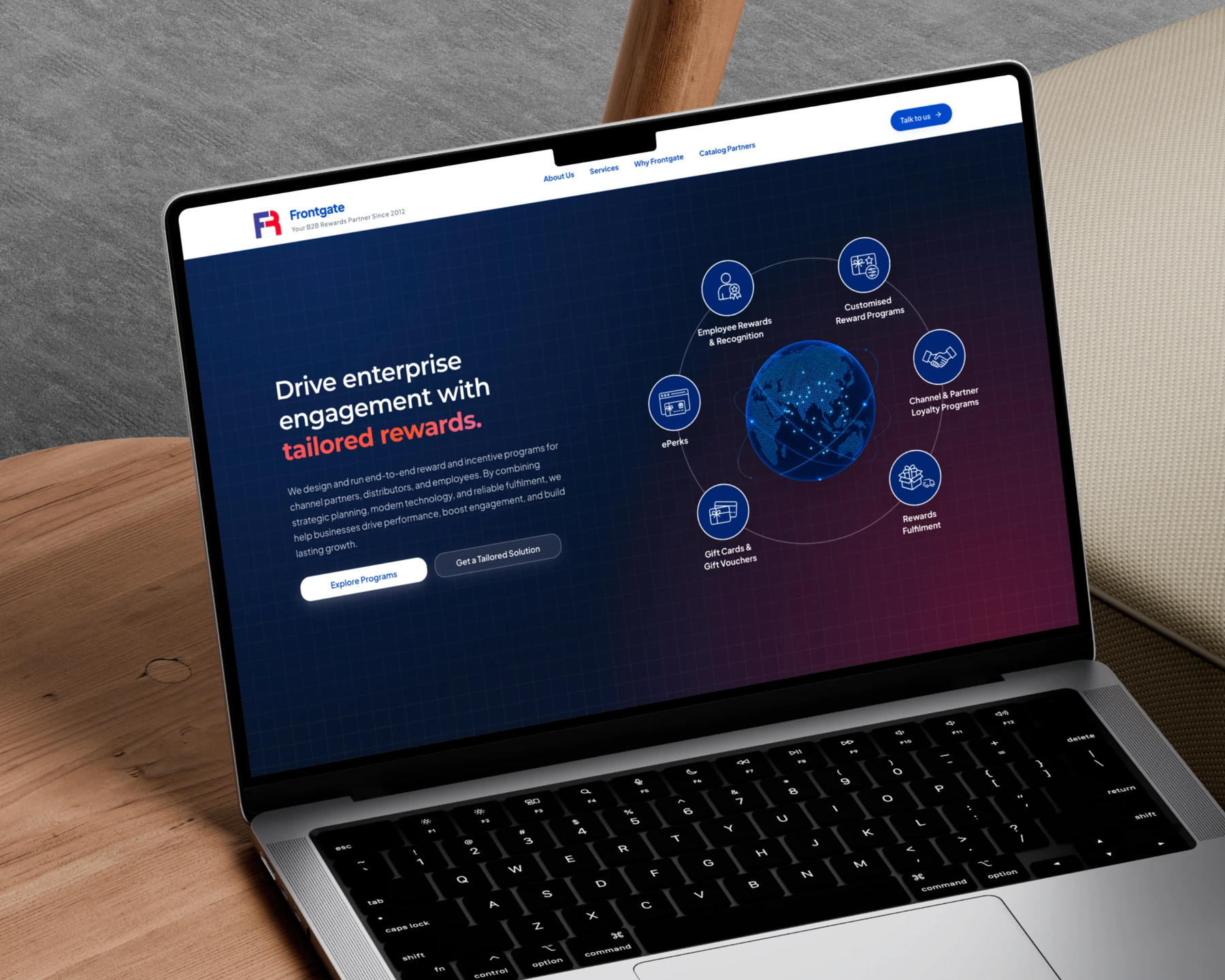The Frontgate homepage open on a laptop on a wooden side table